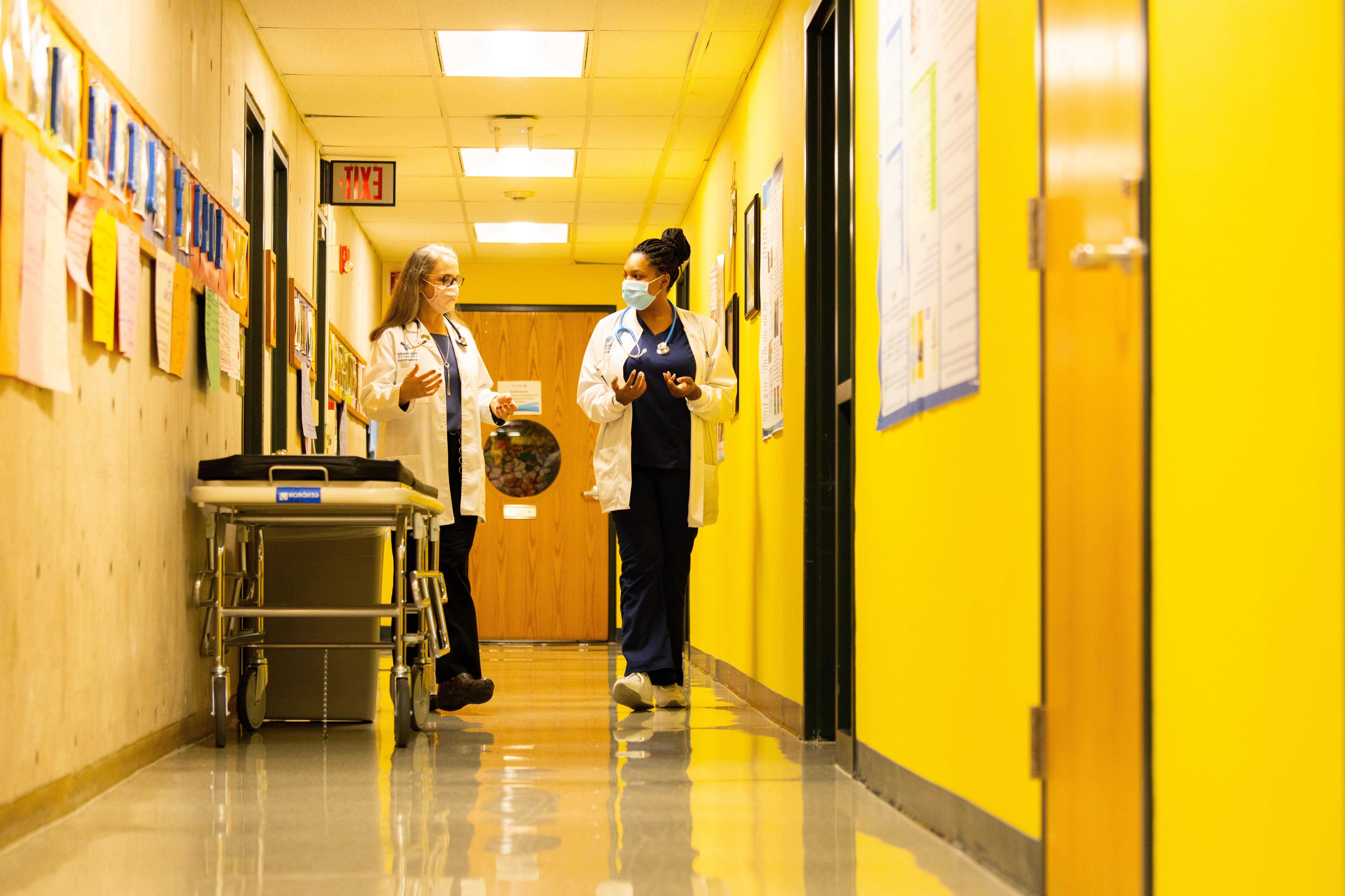 Dr. and student walk through Nursing Education Center